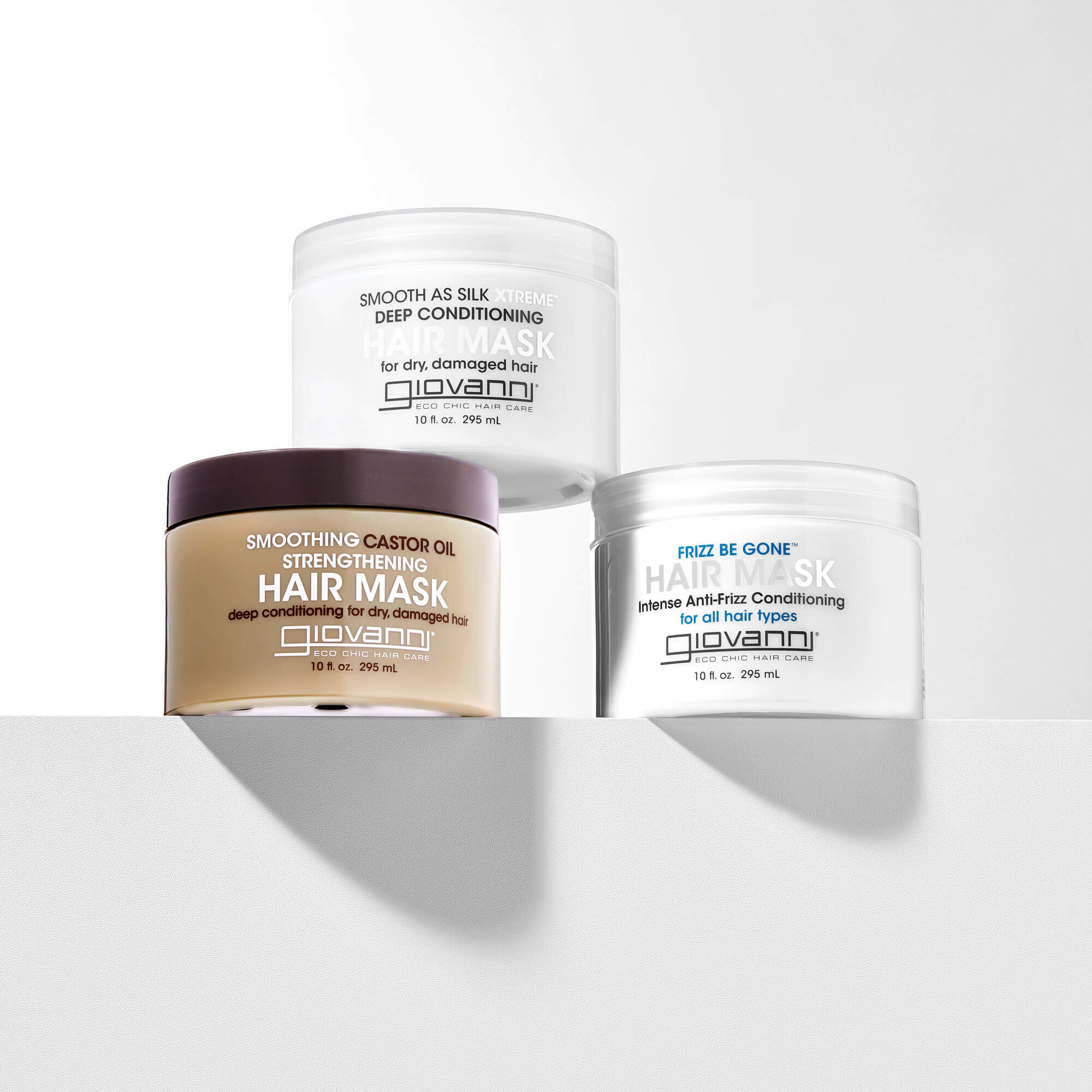 Three Giovanni hair mask containers on a white background: Smooth as Silk, Frizz Be Gone, and Smoothing Castor Oil. Each jar highlights different deep conditioning benefits for hair.