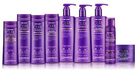 Nine purple bottles and jars of Giovanni Curl Defining hair products, including shampoo, conditioner, leave-in conditioner, no-foam shampoo, hair mousse, and gel, arranged in a row against a white background.