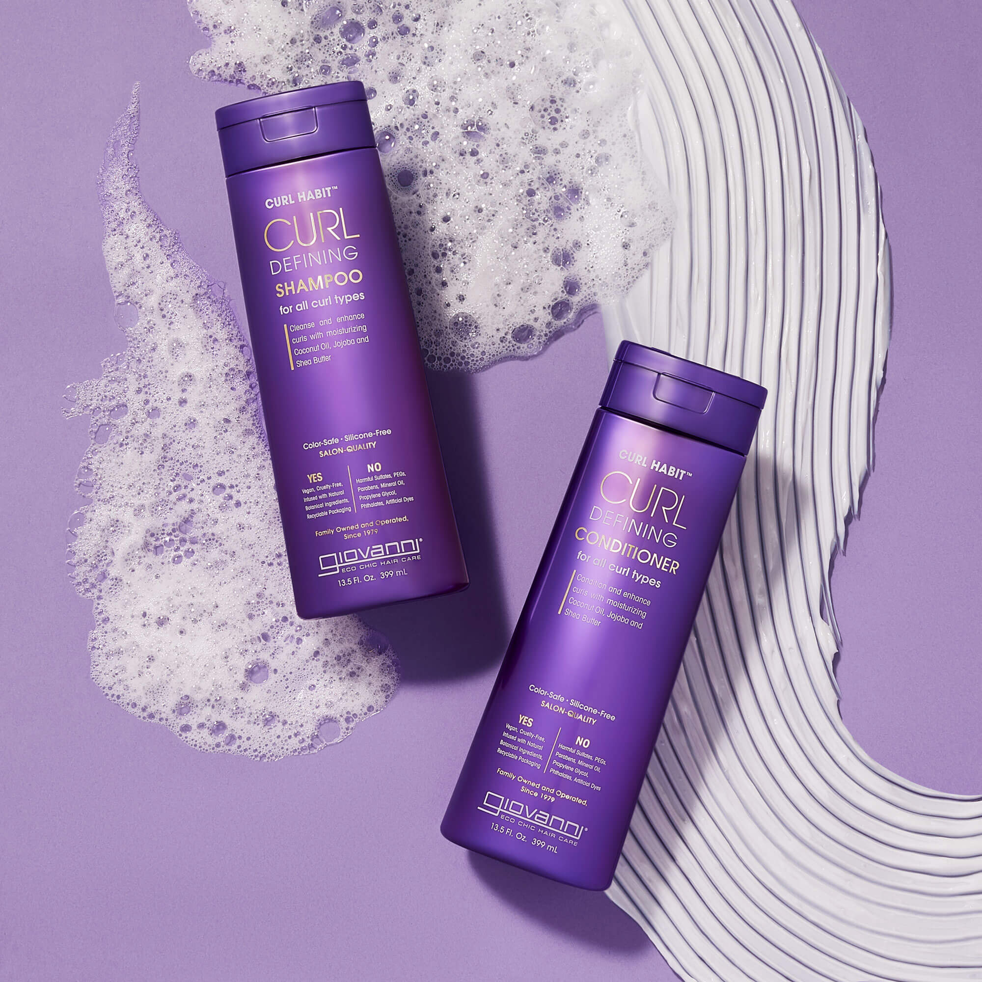 Two purple bottles of Giovanni Curl Defining Shampoo and Conditioner are placed on a lavender surface with white shampoo and conditioner swirls around them, creating a stylish and clean composition.
