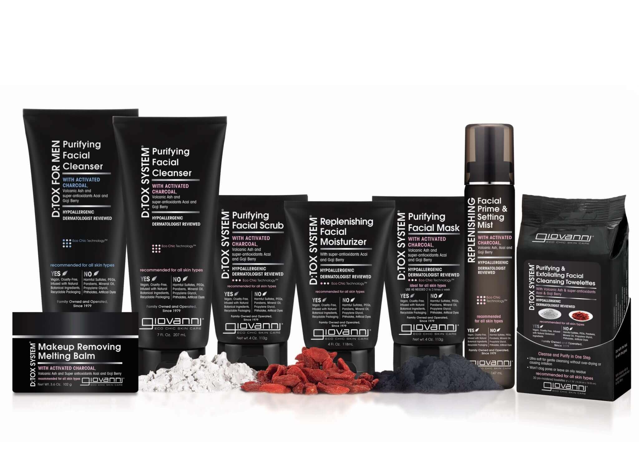 A lineup of Giovanni D:Tox System skincare products, including cleansers, scrubs, moisturizer, facial mask, setting mist, melting balm, and cleansing wipes, displayed with natural ingredients in front.