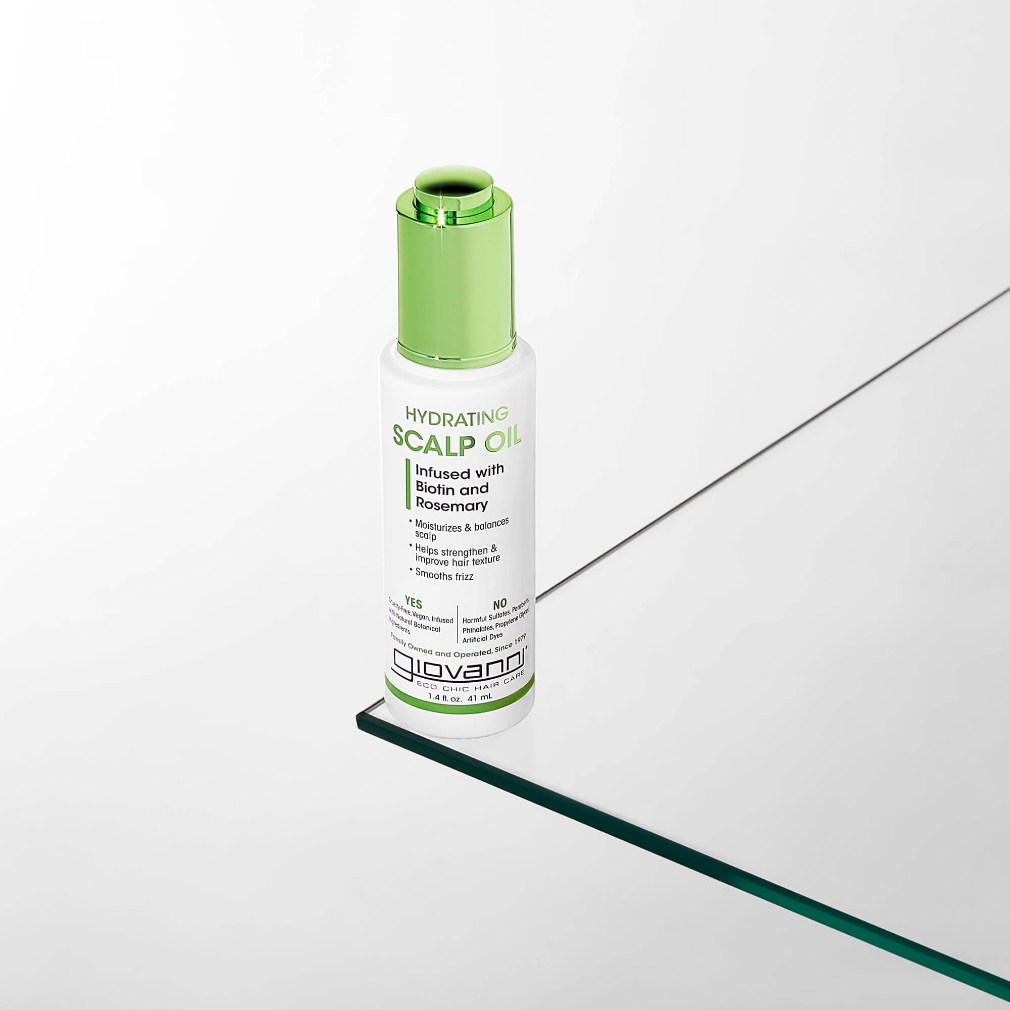 A white and green bottle of Giovanni Hydrating Scalp Oil with biotin and rosemary is placed on a reflective glass surface with a minimal, light background.