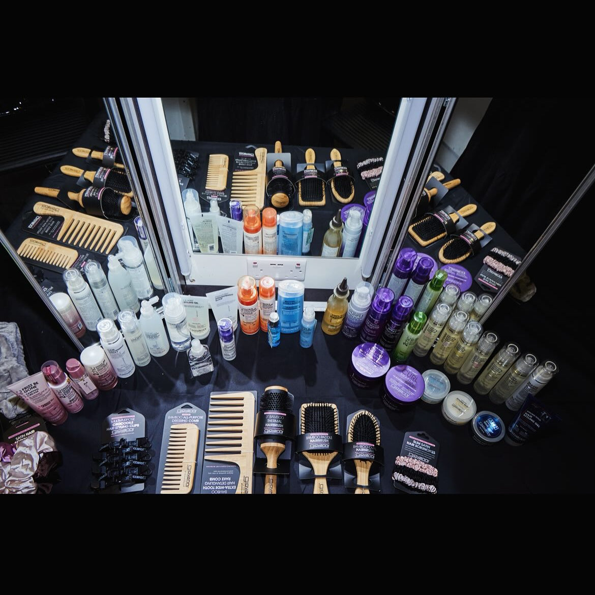 Collection of Giovanni hair care products and tools on a black surface