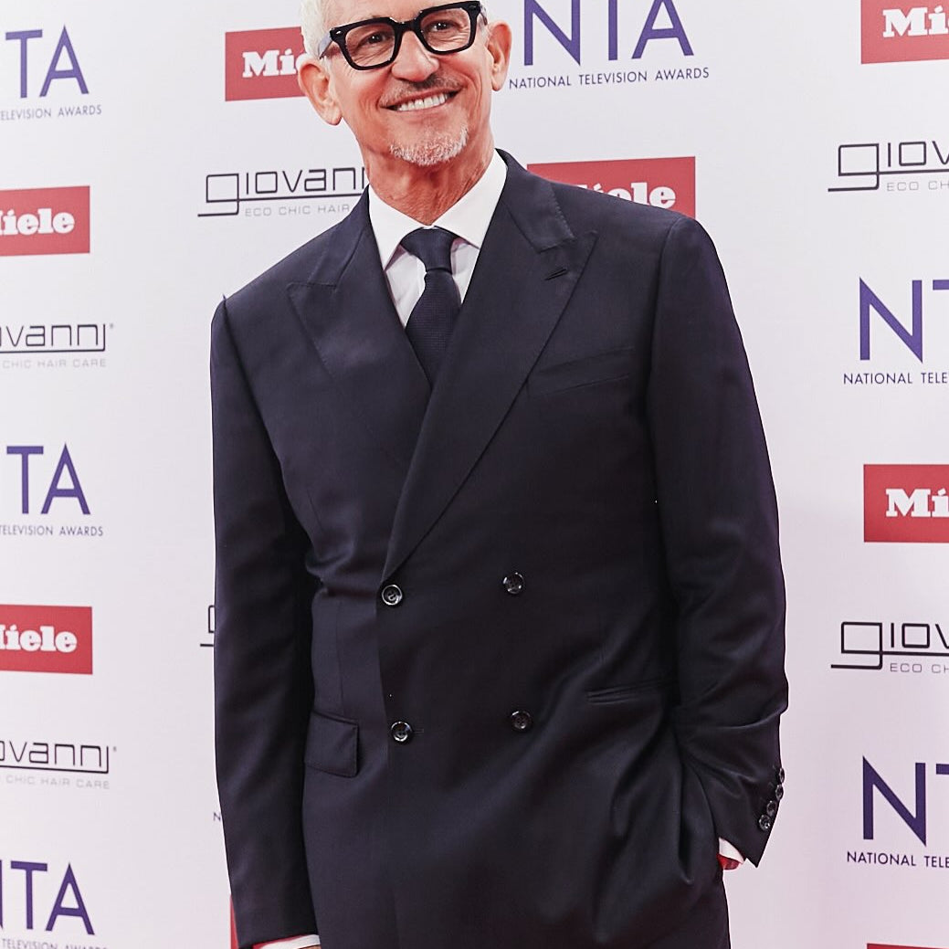 Man in a suit standing in front of the National Television Awards backdrop