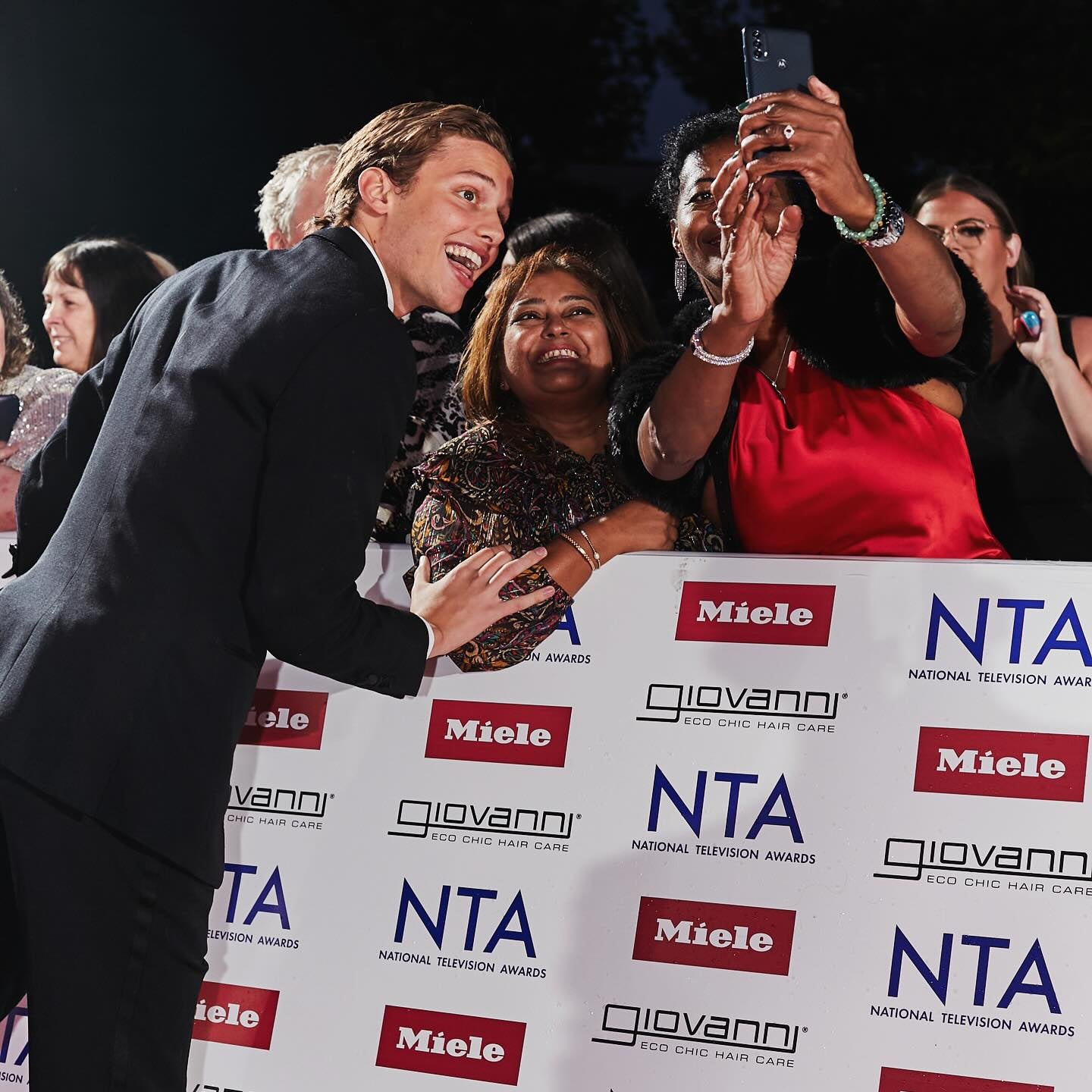 Person in a suit interacting with fans at the National Television Awards