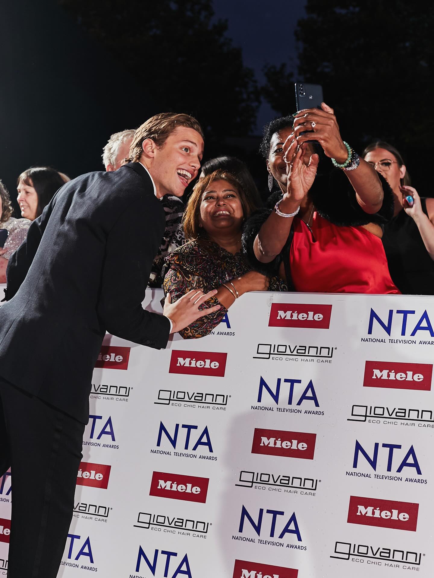 Person in a suit interacting with fans at the National Television Awards
