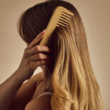 Giovanni Bamboo comb being used to comb blond hair.