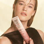 Woman holding bottle of Giovanni Frizz Be Gone Tanning Cream
