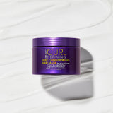 A purple container of Giovanni Cosmetics CURL HABIT™ CURL DEFINING DEEP CONDITIONING HAIR MASK sits on a creamy white background, highlighting its hydrating, curl-enhancing, and moisturizing formula.