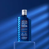 A blue bottle of Giovanni Cosmetics MEN 2-in-1 Daily Shampoo & Conditioner with Ginseng & Eucalyptus sits on a clear stand against a blue background, its front label visible amid soft shadows.