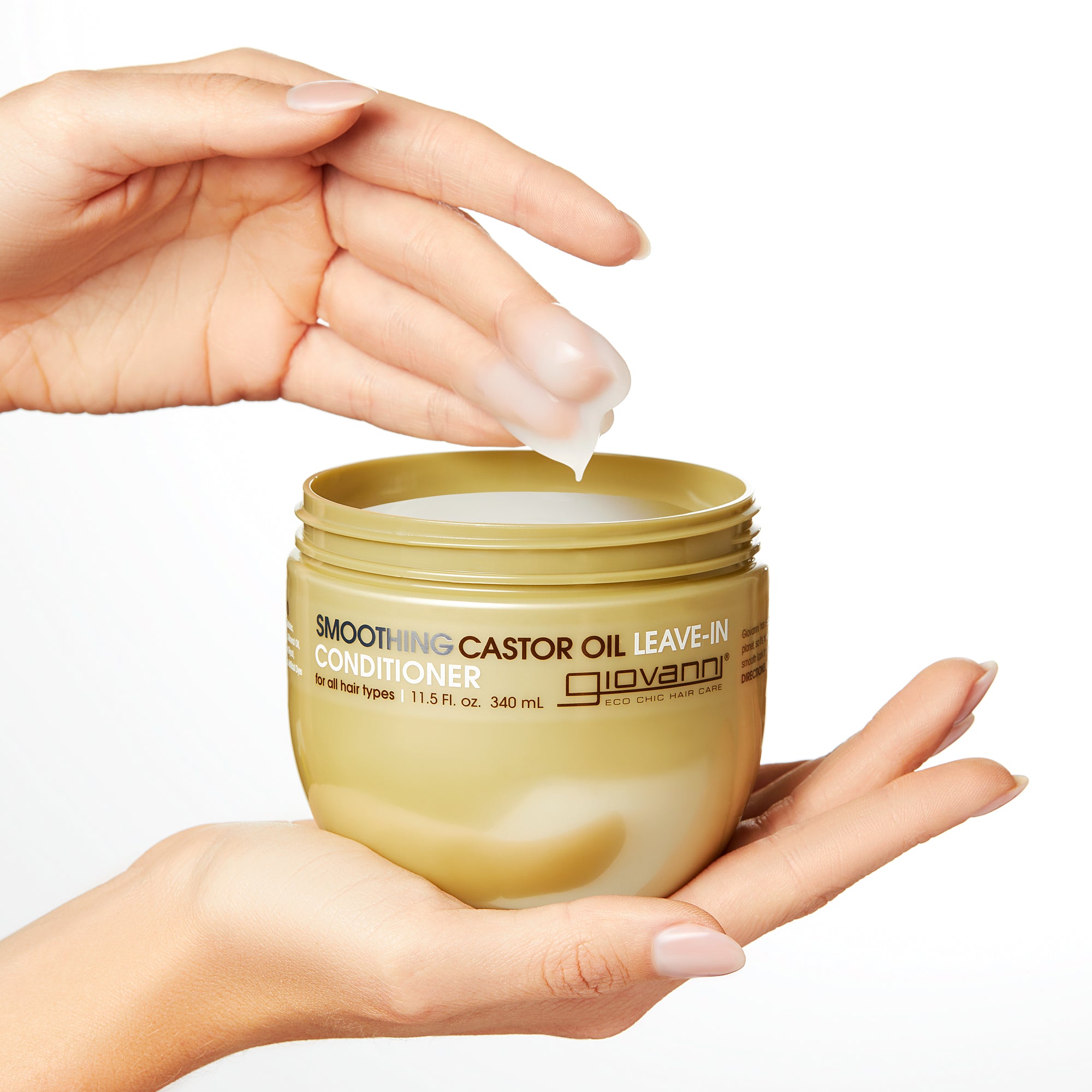 Hands holding jar of Giovanni Smoothing Castor Oil Leave-In Conditioner