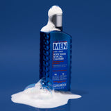 A blue bottle of Giovanni Cosmetics MEN 2-in-1 Daily Body Wash & Facial Cleanser with Ginseng & Eucalyptus stands upright with suds and bubbles on its cap and base, set against a solid blue background.