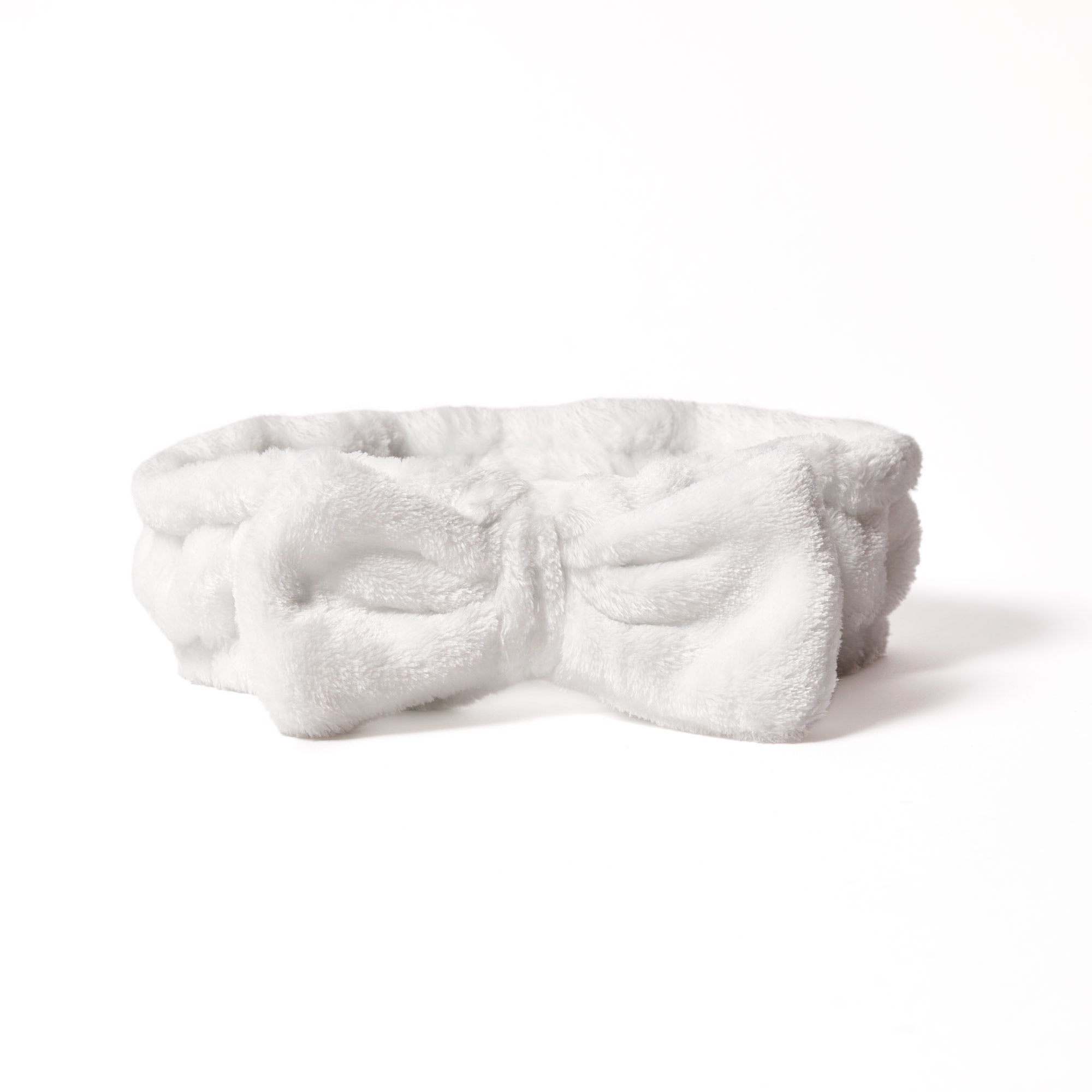 for all types of beauty routines  - The Giovanni Cosmetics PLUSH MULTI-PURPOSE SPA HEADBAND (white) features a soft, plush design with a large front bow—ideal for beauty routines—and is shown against a plain white background.
