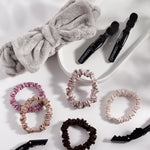 Five slim satin hair scrunchies in pink, beige, mauve, copper, and dark brown from Giovanni Cosmetics are arranged on a white surface with a white tray—perfect for elevating your daily hair care routine.