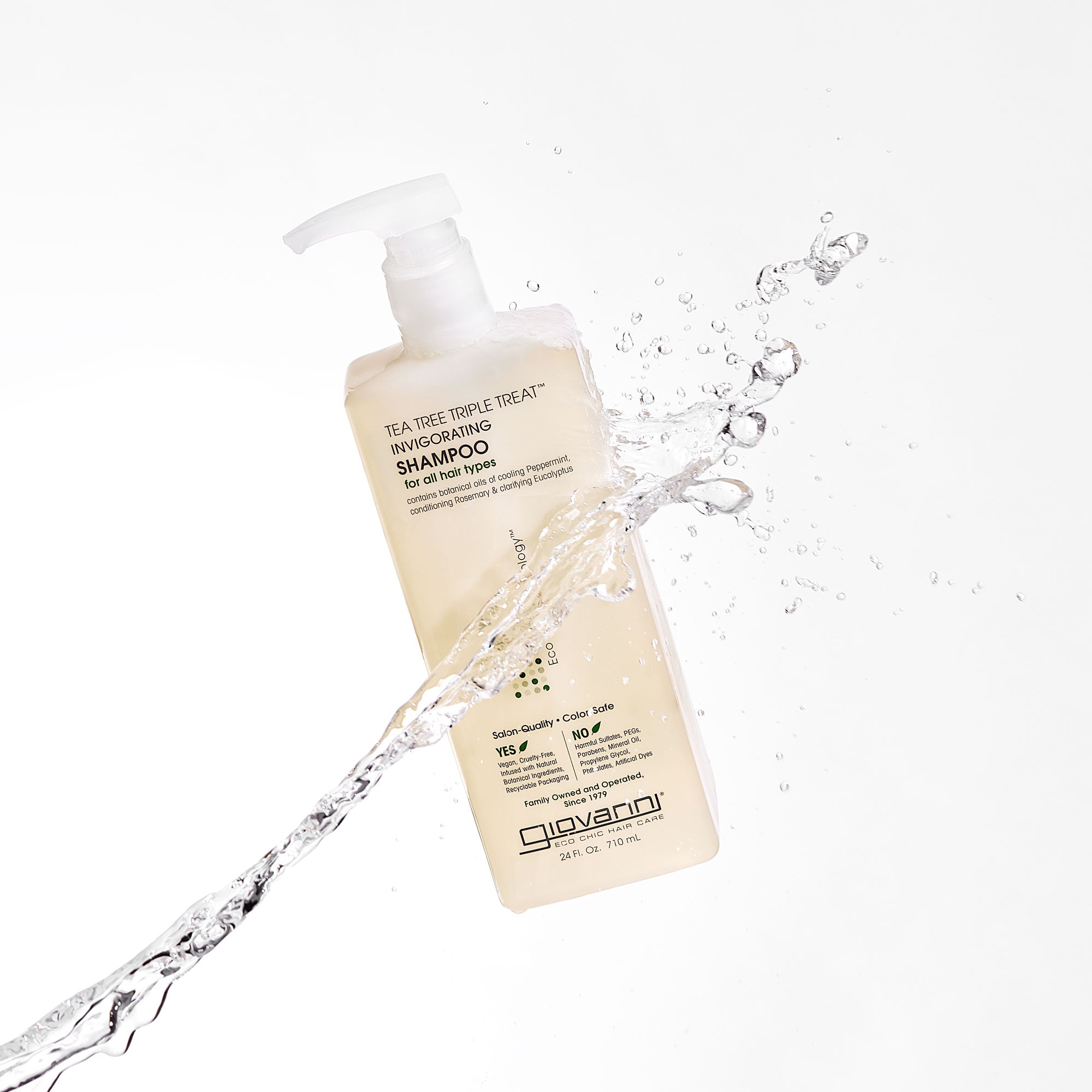 Giovanni Tea Tree Triple Treat Invigorating shampoo bottle with water splash on a white background