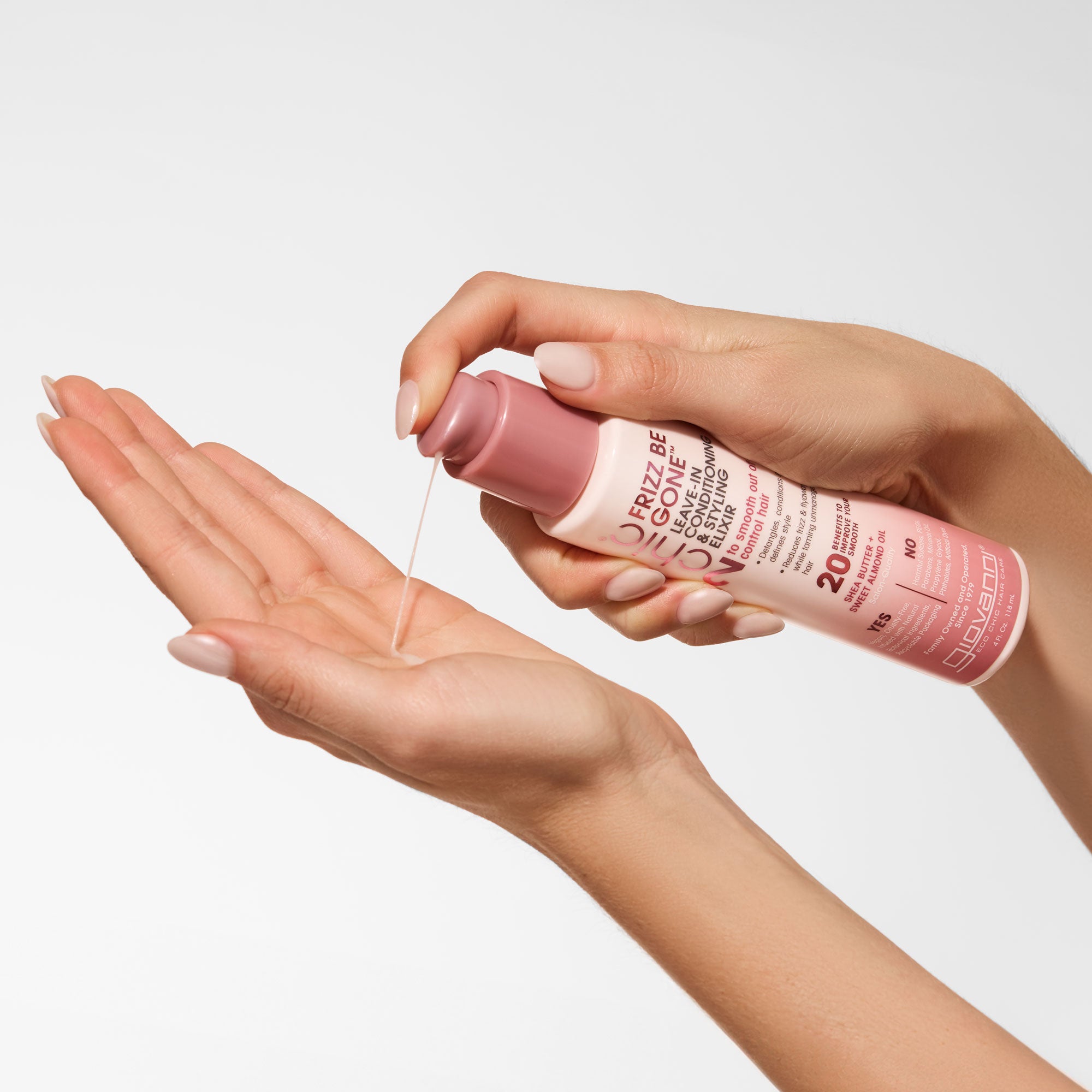 Hands holding bottle Giovanni 2Chic Frizz Be Gone Leave-In Conditioning & Styling Elixir
