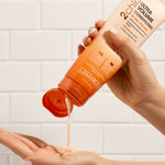 Hands holding bottle of Giovanni 2chic Ultra Volume Conditioner
