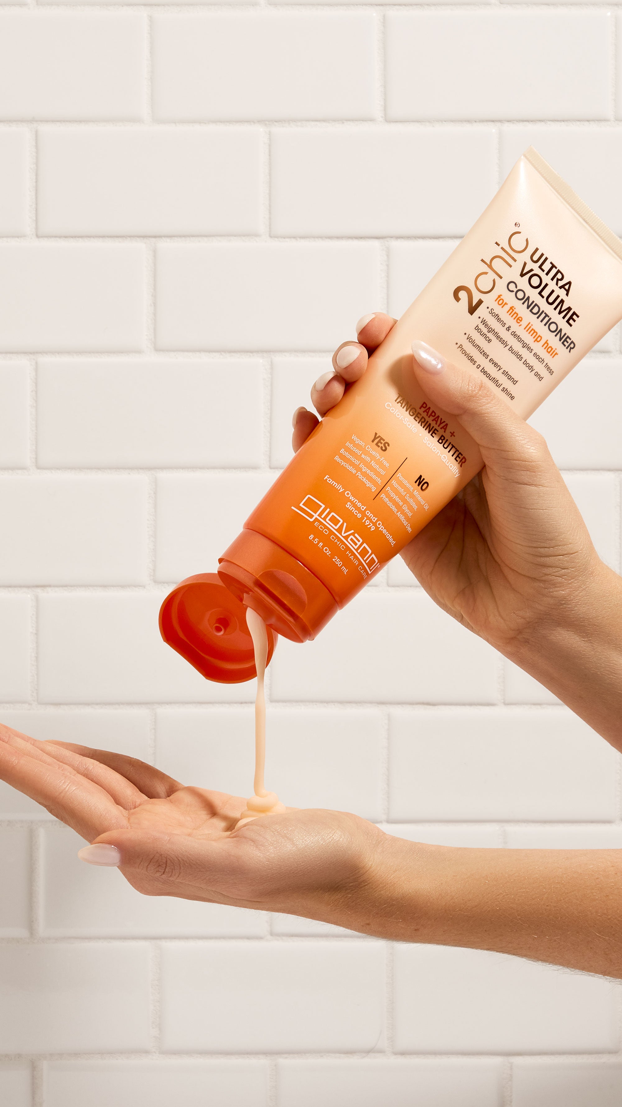 Hands holding bottle of Giovanni 2chic Ultra Volume Conditioner
