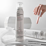 Giovanni hair texturizing spray bottle on a white surface with a hand holding a spray nozzle.