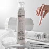 Giovanni hair texturizing spray bottle on a white surface with a hand holding a spray nozzle.
