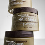 3 bottles of Smoothing Castor Oil Strengthening Hair Mask stacked on top of each other with water drops