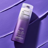 A bottle of Giovanni Cosmetics COLOR CHIC™ PURPLE CONDITIONER for blonde or silver hair stands upright on a textured purple surface, with matching conditioner streaks nearby and the label clearly visible.