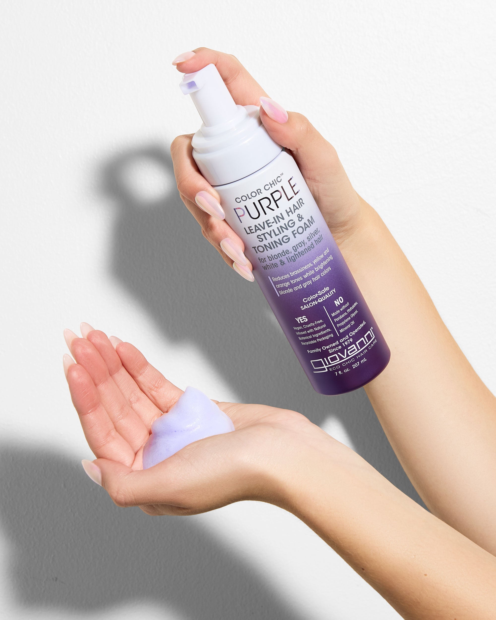 Giovanni Purple hair care product being held by a person with a neutral background