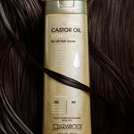 Giovanni Smoothing Castor Oil Conditioner bottle on a background of dark hair