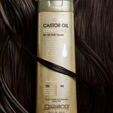 Giovanni Smoothing Castor Oil Conditioner bottle on a background of dark hair