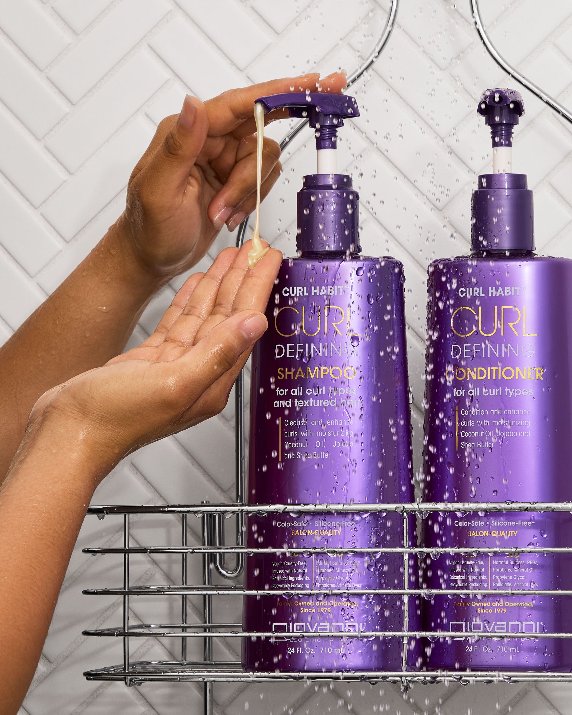 Person applying CURL HABIT shampoo to their hand with two purple bottles of Curl Define Shampoo and Conditioner in the background.