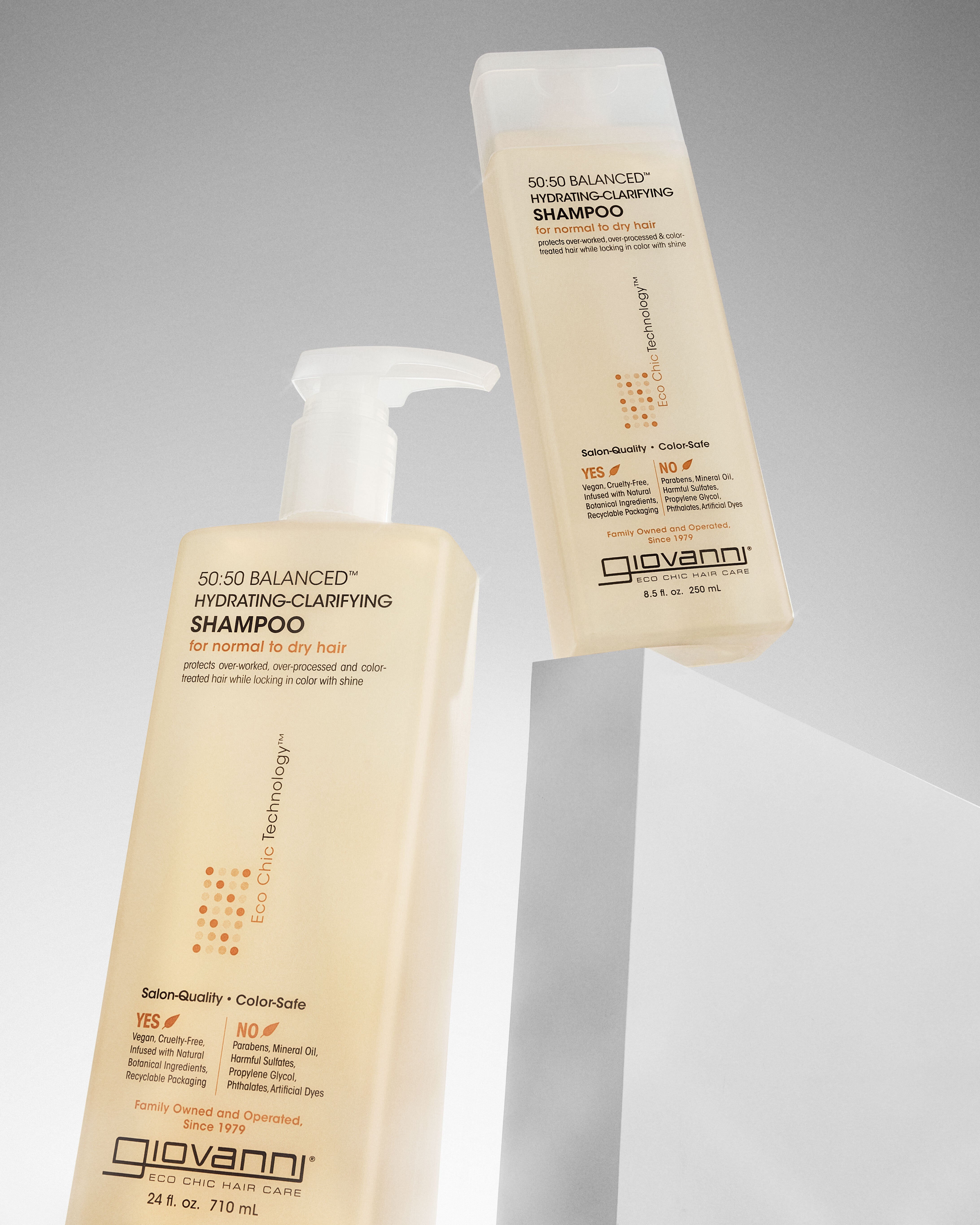 Two bottles of Giovanni 50:50 Balanced Hydrating-Clarifying shampoo on a gray background