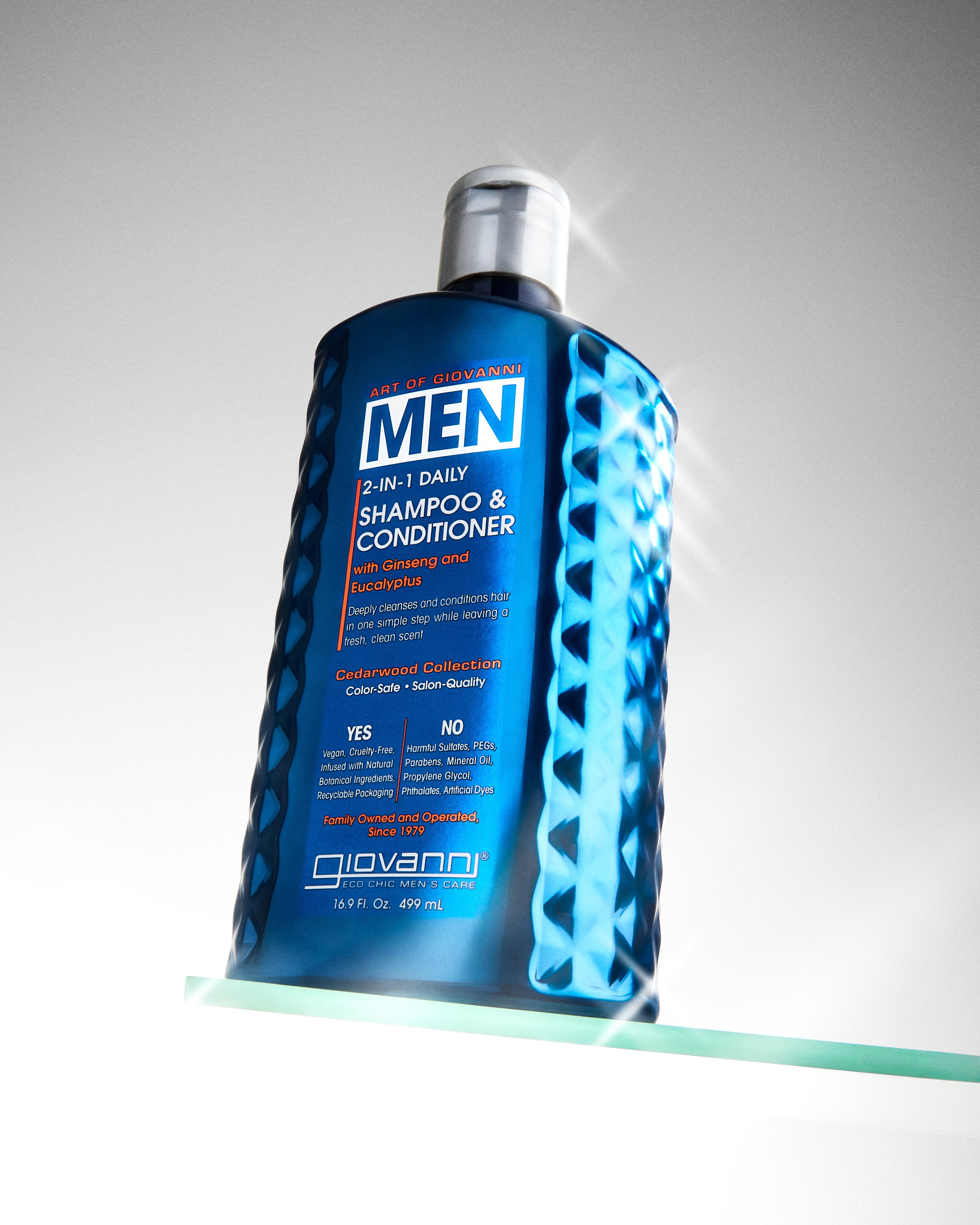 Blue bottle of Giovanni Men's shampoo and conditioner on a gray background