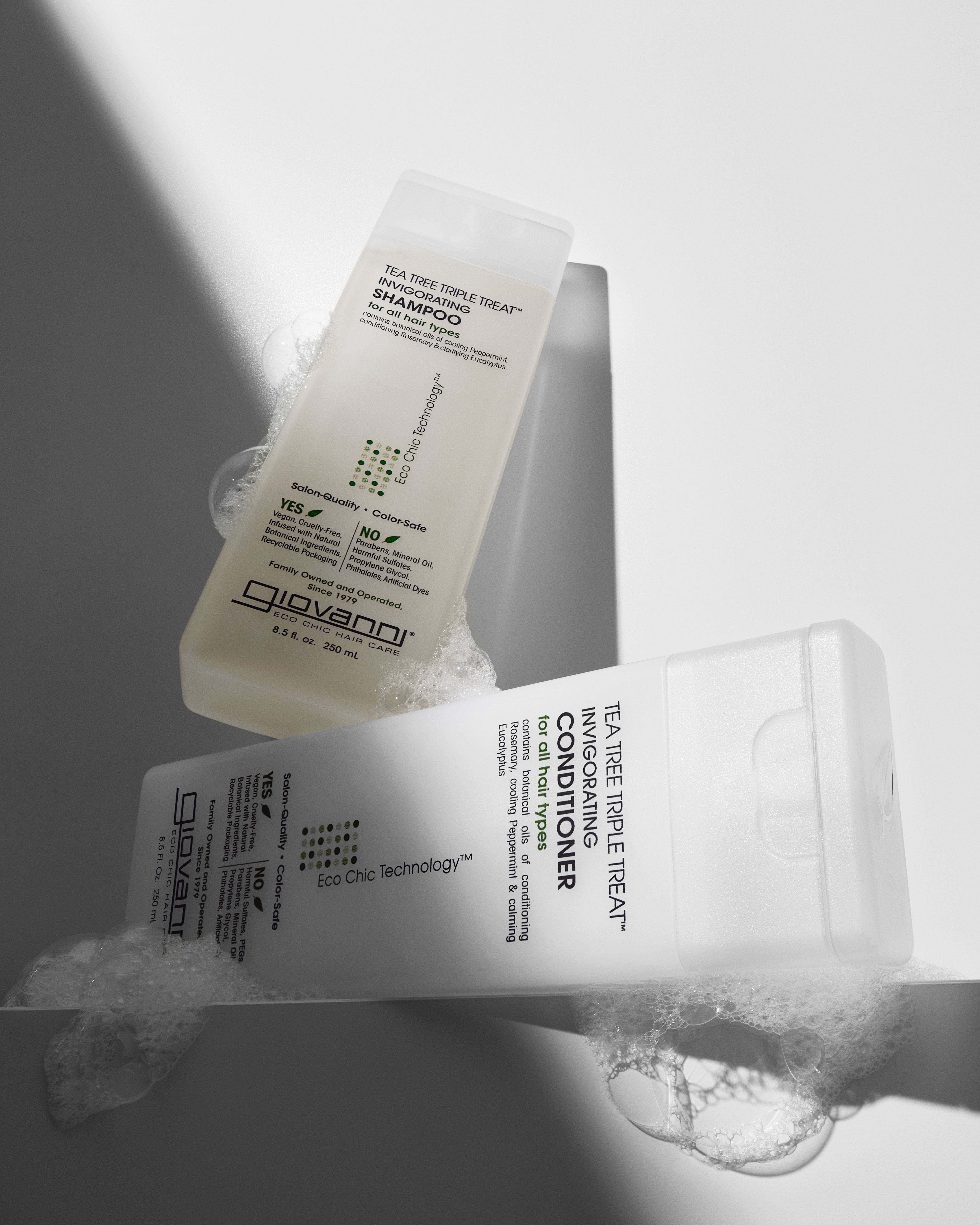 Two bottles of Giovanni hair care products on a gray background