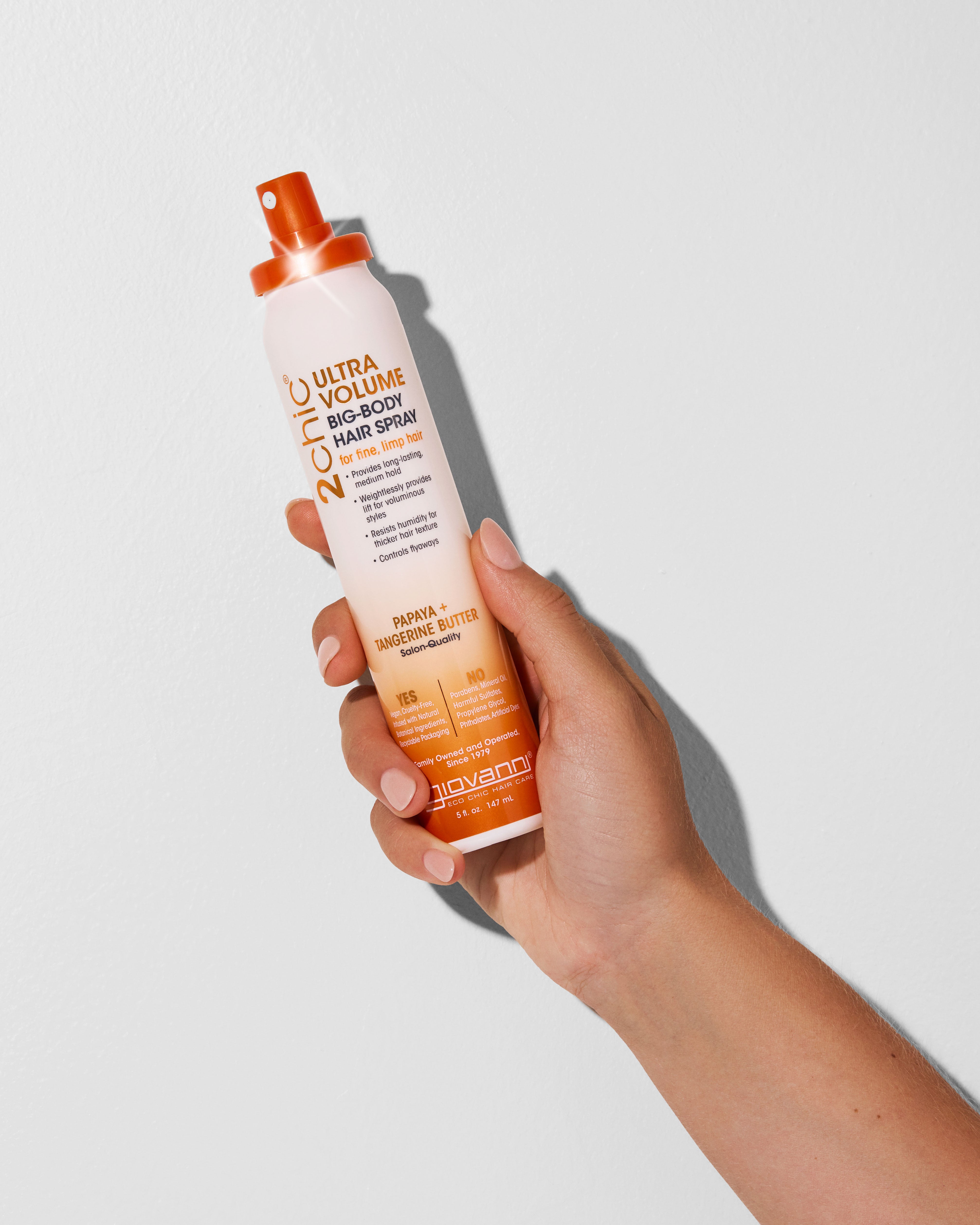 Hand holding a bottle of 2chic Ultra Volume big-body hair spray