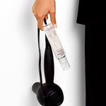 Hand holding a hair dryer and Giovanni Rapid Blow-Dry Shield & Style Spray