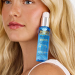 Woman holding a bottle of Giovanni Biotin & Collagen Restore Hair Oil