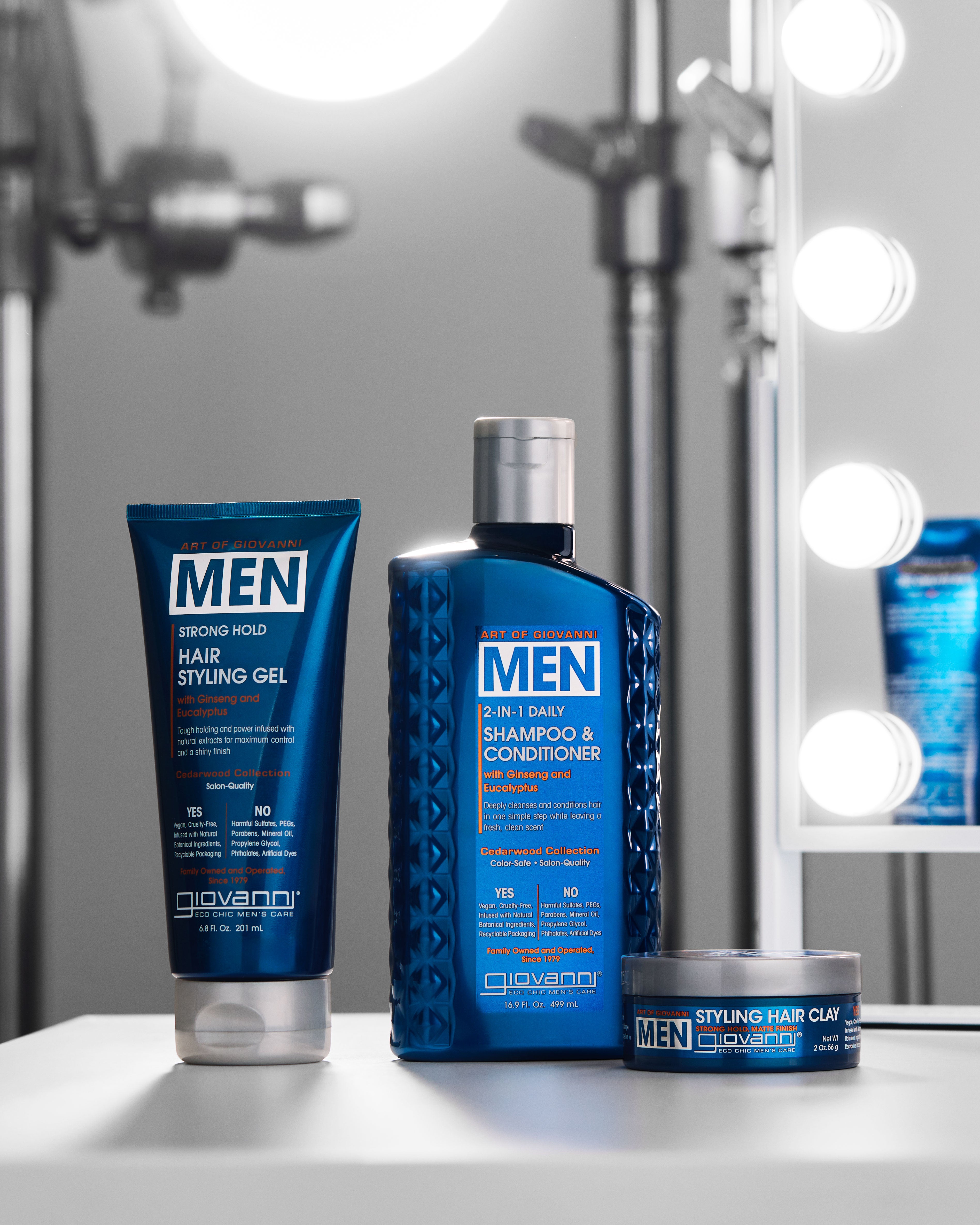 Giovanni Men's hair styling products including shampoo, styling gel, and clay on a vanity table.