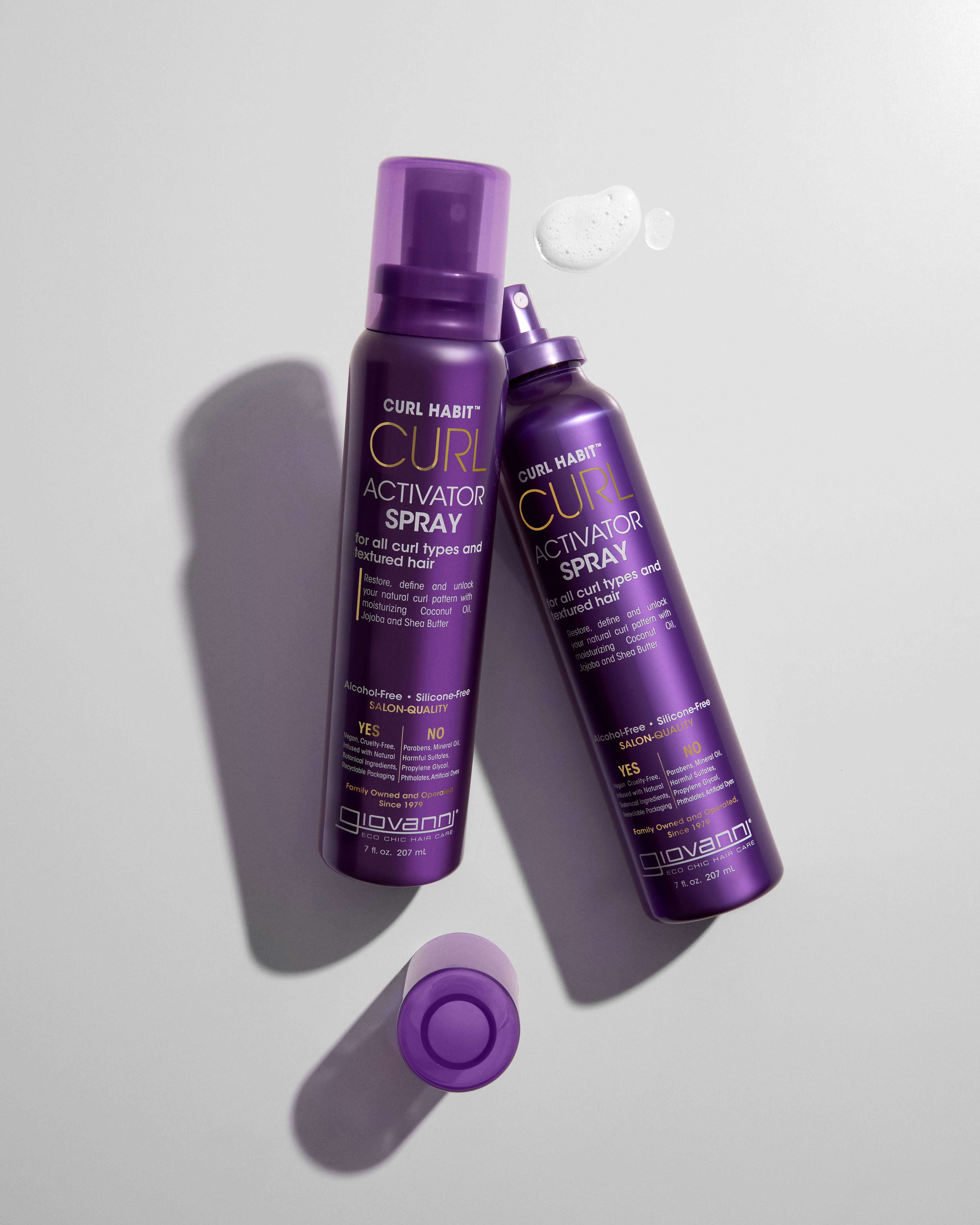 Two bottles of Giovanni Curl Activator Spray on a light gray background