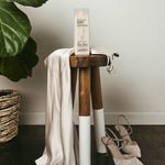 Wooden stool with a white cloth draped over it, with bottle of Smooth as Silk Deep Moisture Shampoo