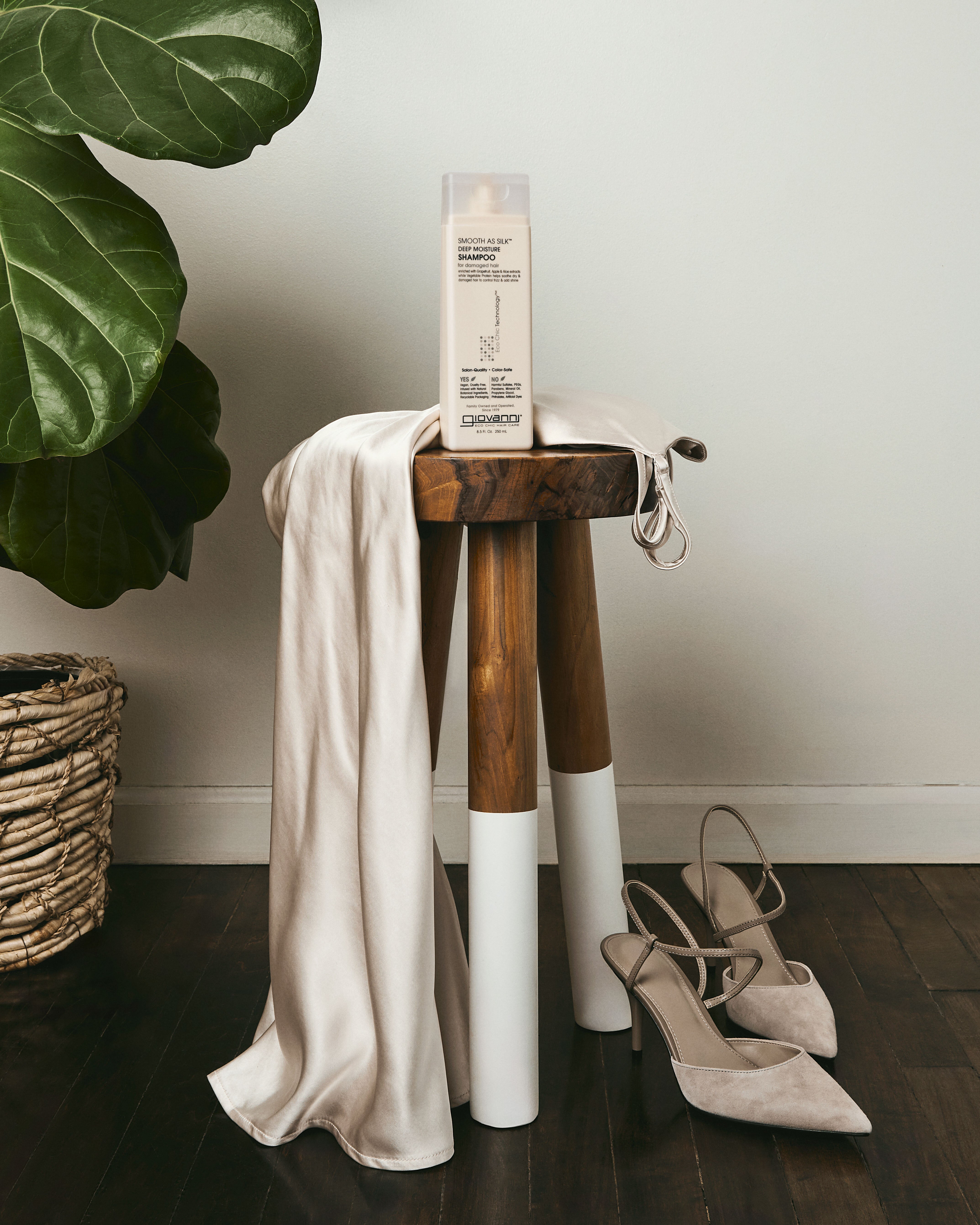 Wooden stool with a white cloth draped over it, with bottle of Smooth as Silk Deep Moisture Shampoo