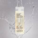 Bottle of Giovanni Golden Wheat Deep Cleanse Shampoo with water splashing