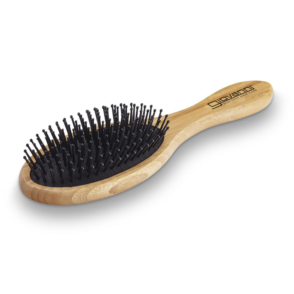 The Giovanni Cosmetics BAMBOO OVAL HAIRBRUSH features a light brown bamboo handle with the Giovanni logo in black, black bristles, and rounded tips. This salon-quality, sustainable styling tool is shown on a white background.