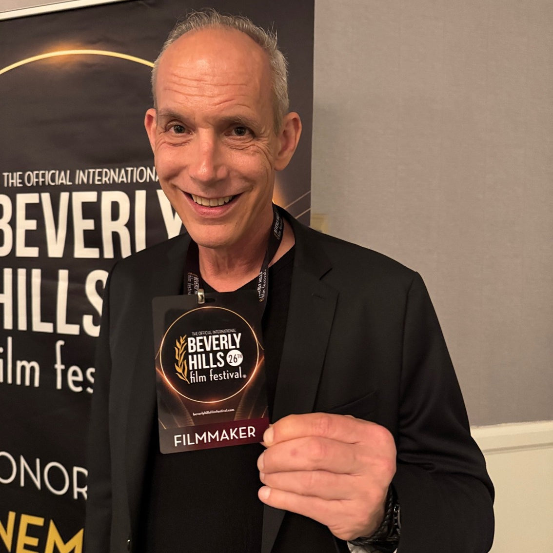 Giovanni James Guidotti holding a 'Beverly Hills Film Festival' badge