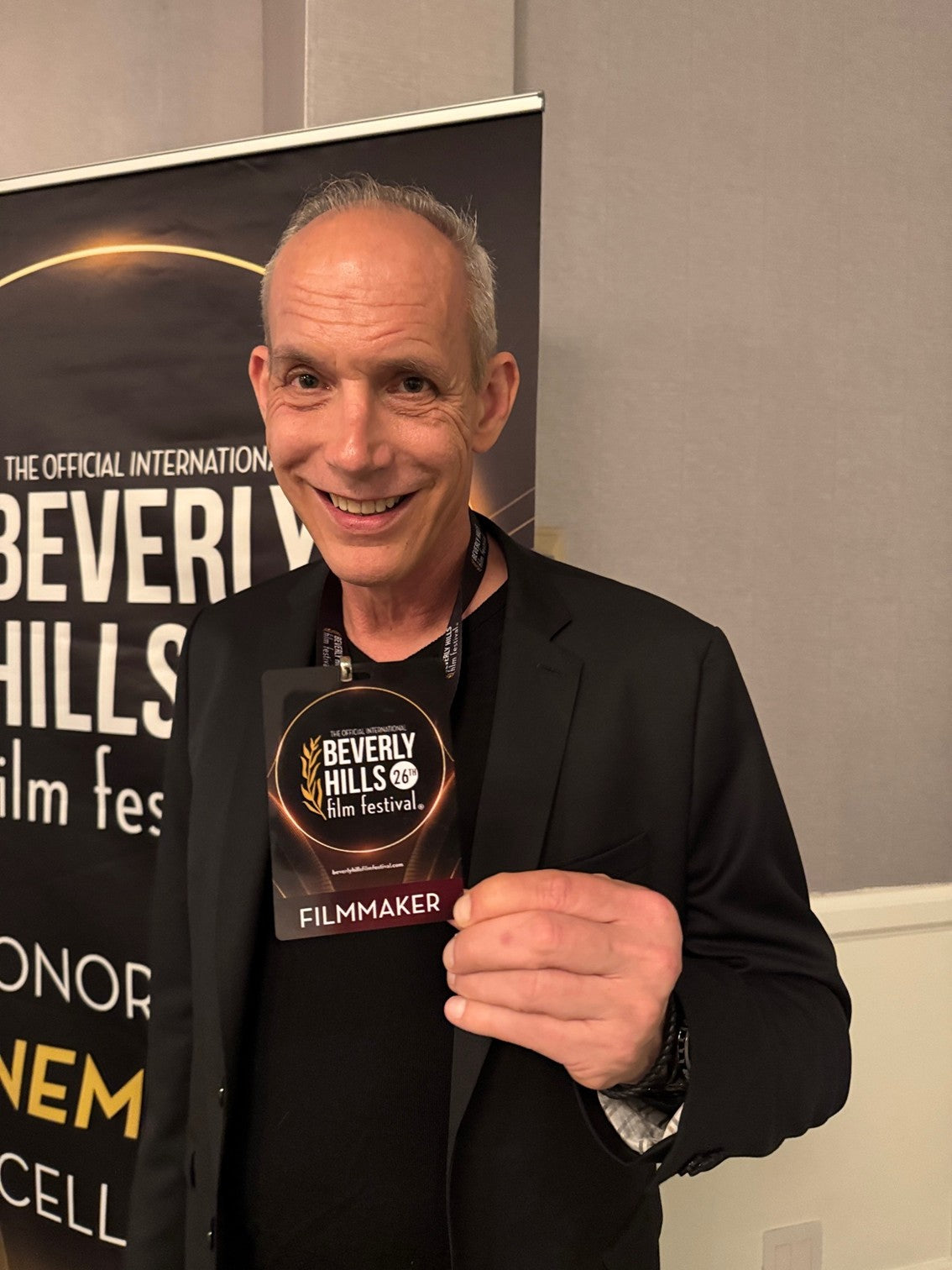 Giovanni James Guidotti holding a 'Beverly Hills Film Festival' badge