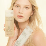 Woman holding bottles of Tea Tree Triple Treat Invigorating Shampoo and Conditioner