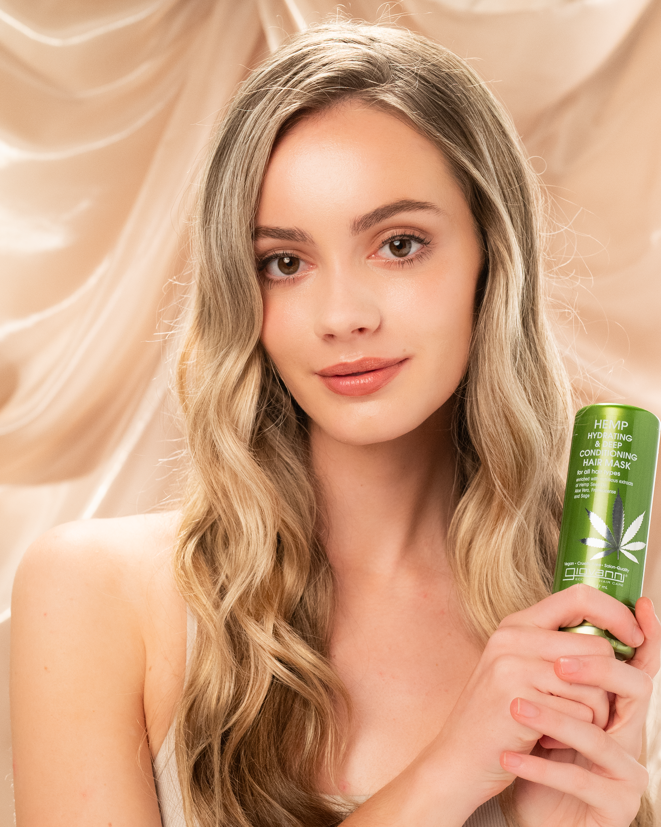 Model holding Giovanni Hemp Hydrating & Deep Conditioning Hair Mask