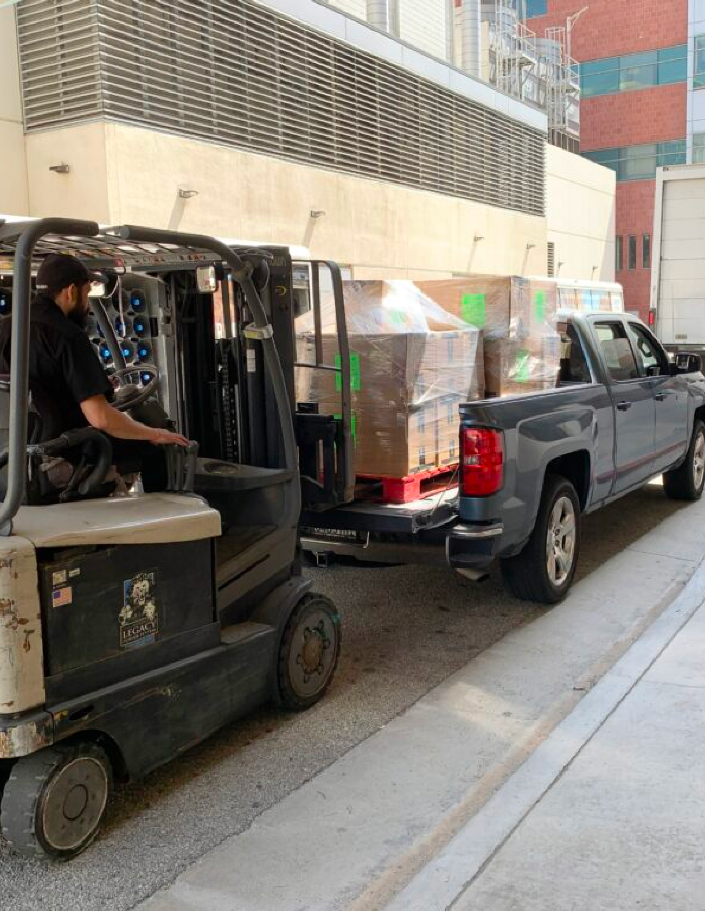 Fork lift loading boxes in the back of a pickup truck