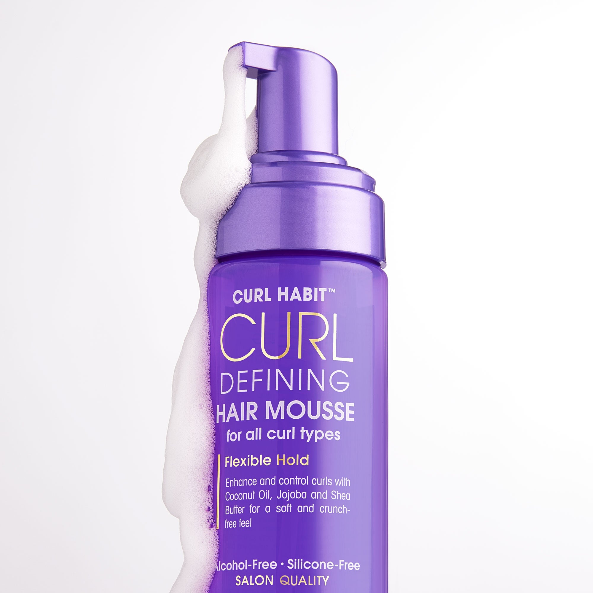 A purple bottle of Giovanni Cosmetics CURL HABIT™ Curl Defining Hair Mousse with foam spilling over, featuring flexible hold, coconut oil, and shea butter for nourishing all curl types.