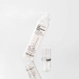 A white spray bottle labeled Giovanni Cosmetics SMOOTH AS SILK™ HAIR DETANGLING SPRAY mists on a white background, promising tangle-free hair. Its transparent cap rests beside the bottle.