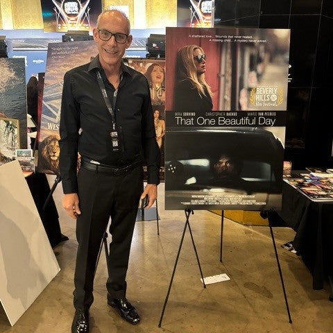 Giovanni James Guidotti standing in front of That One Beautiful Day movie poster