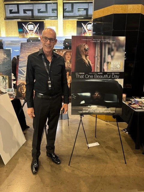 Giovanni James Guidotti standing in front of That One Beautiful Day movie poster